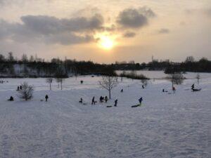 Sonnenuntergang über dem schneebedecktem Hügel
