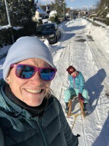 Katrin Weber mit Tochter auf Schlitten