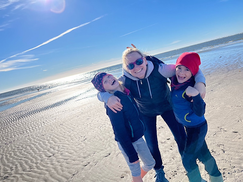 Mutter mit zwei Kindern am Strand