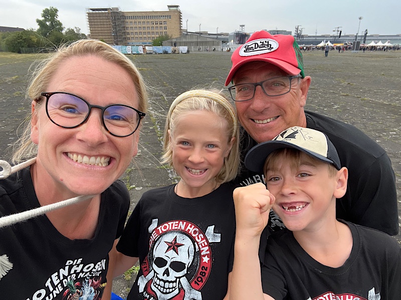 Familie schaut in die Kamera und lacht