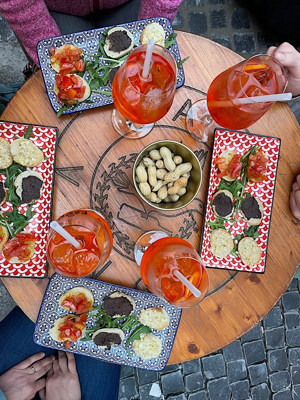 Ein Tisch mit Aperol Spritz Gläsern und Bruschetta